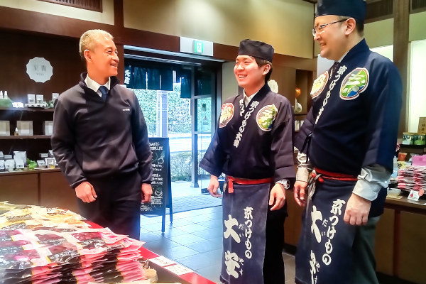 店舗で従業員と話す大角社長